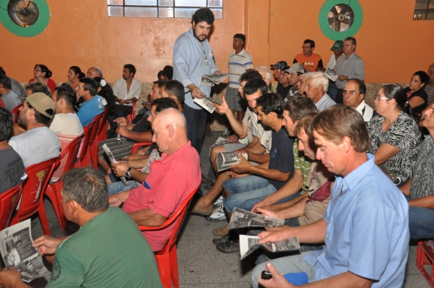 O educador ambiental Cauê Canabarro distribuindo material informativo para o público da palestra