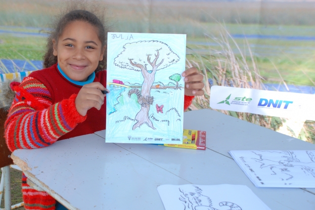A moradora do Balneário Barro Duro, Júlia, mostra como ficou colorido o mascote da Gestão Ambiental da BR-116/392 - 08 de julho de 2012